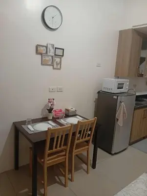 a small kitchen with a table and a clock on the wall at Condo MOA Complex Pasay - Shore 1 Tower C2 Residence - Home away from Home in Manila