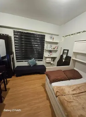 a bedroom with two beds and a window with blinds at Casa Tolentino Manila in Manila