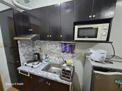 a small kitchen with a sink and a microwave at Casa Tolentino Manila in Manila