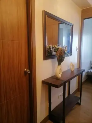 a mirror and a vase on a table in a room at Cozy Staycation Suite at Rossy's Place near in Paranaque in Manila