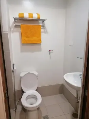 a bathroom with a white toilet and a sink at Cozy Staycation Suite at Rossy's Place near in Paranaque in Manila