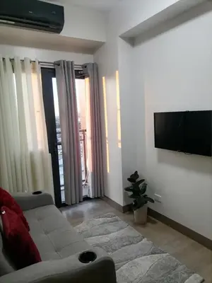 a living room with a couch and a flat screen tv at Cozy Staycation Suite at Rossy's Place near in Paranaque in Manila