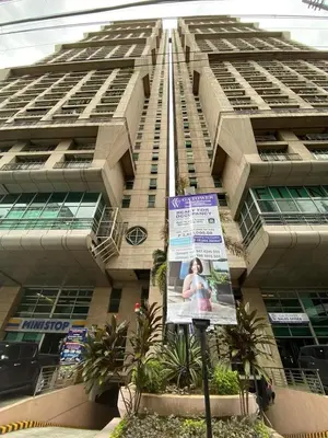 a tall building with a sign in front of it at Whereabouts Midway Condotel in Manila