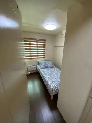 a small room with a bed and a window at Whereabouts Midway Condotel in Manila