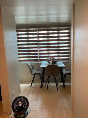 a dining room with a table and chairs and a window at Whereabouts Midway Condotel in Manila