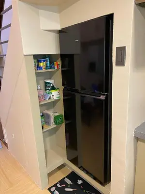 a kitchen with a black refrigerator in a house at Whereabouts Midway Condotel in Manila