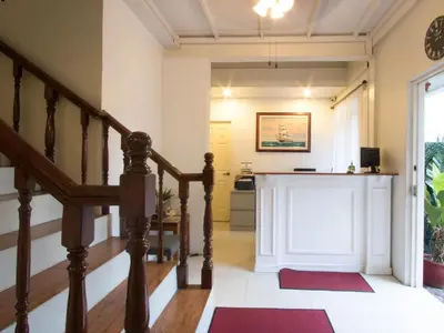 a hallway with a staircase with red mats and a fireplace at Makati Riverside Inn in Manila