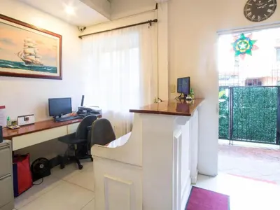 an office with a desk with a computer and a window at Makati Riverside Inn in Manila
