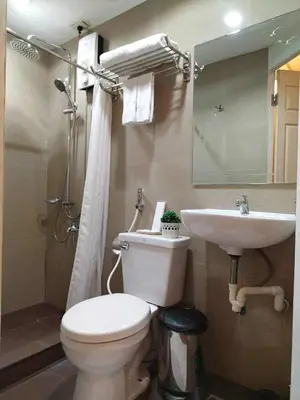 a bathroom with a toilet and a sink at Makati Riverside Inn in Manila