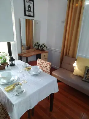 a living room with a table and a couch at Makati Riverside Inn in Manila