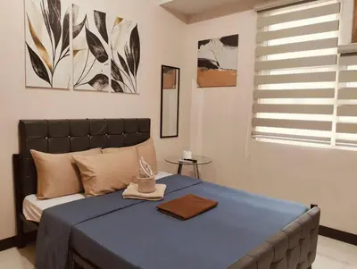 a bedroom with a bed with blue sheets and a window at NAIA Manila Airport - Newport Prime Accommodations in Manila