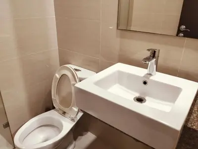 a bathroom with a white sink and a toilet at NAIA Manila Airport - Newport Prime Accommodations in Manila