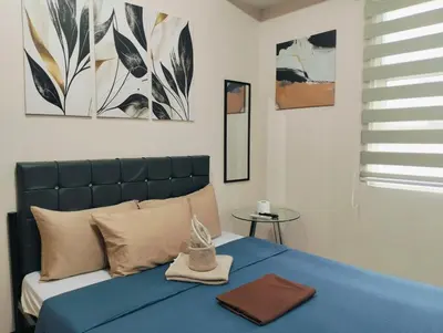 a bedroom with a bed with a blue comforter at NAIA Manila Airport - Newport Prime Accommodations in Manila