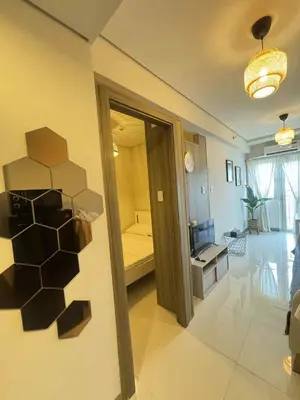 a living room with a room with a bed and a doorway at Canadian Suite at Coast Residences Penthouse in Manila