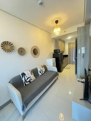 a living room with a couch and a kitchen at Canadian Suite at Coast Residences Penthouse in Manila