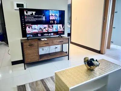 a living room with a flat screen tv on a table at Upscale 2BR in Uptown Parksuites with Free Parking in Manila