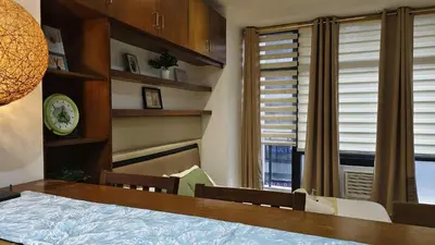 a dining room with a table and a window at Christine Suites PH at The Gramercy Residences Makati in Manila