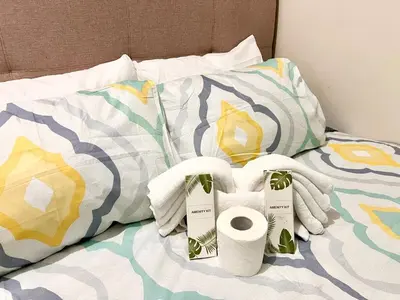 a bed with two rolls of toilet paper and towels at Skyline Serenity Designer 1BR with Balcony at Air in Manila