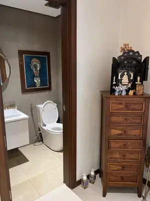 a bathroom with a toilet and a wooden dresser at Super cozy Family Villa in Manila
