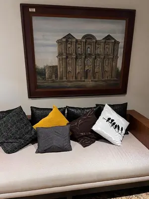 a couch with pillows on it with a painting at Super cozy Family Villa in Manila