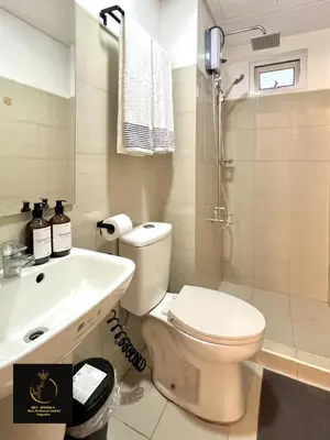 a bathroom with a toilet and a sink and a shower at Masie Beach Staycation in Manila