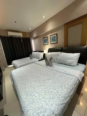 two beds in a hotel room withskirts at MOA Shell Residences Staycation in Manila