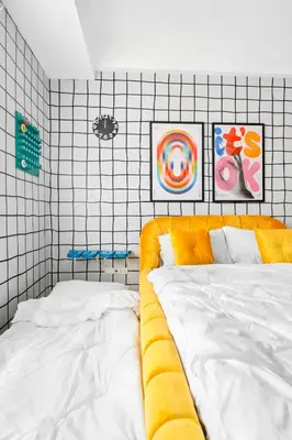 a bedroom with a white bed and some paintings at The Play Haus Aesthetic Studio across NAIA Terminal 3 in Manila