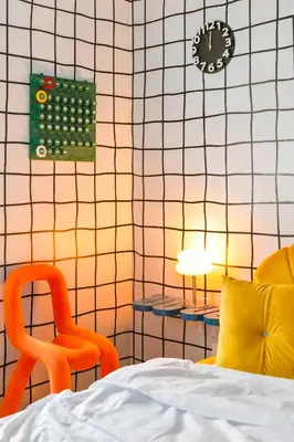 a bedroom with a bed and a chair and a clock at The Play Haus Aesthetic Studio across NAIA Terminal 3 in Manila