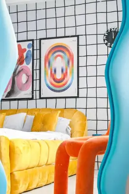 a living room with a yellow couch and some pictures at The Play Haus Aesthetic Studio across NAIA Terminal 3 in Manila