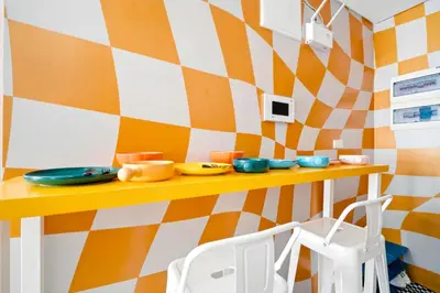 a kitchen with orange and white checkered wall at The Play Haus Aesthetic Studio across NAIA Terminal 3 in Manila