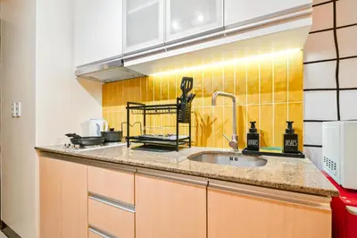 a kitchen with a sink and a yellow tiled wall at The Play Haus Aesthetic Studio across NAIA Terminal 3 in Manila