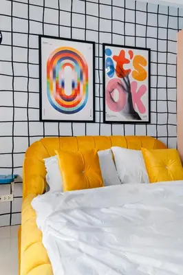 a bedroom with a yellow bed with two pictures on the wall at The Play Haus Aesthetic Studio across NAIA Terminal 3 in Manila