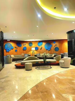 a lobby with couches and tables in a building at Casa Felice at Shore 2 Residences in Manila
