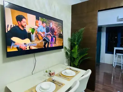 a tv hanging on a wall in a living room at Tropical Chic Escape With City lights View- Modern Scandi in Manila