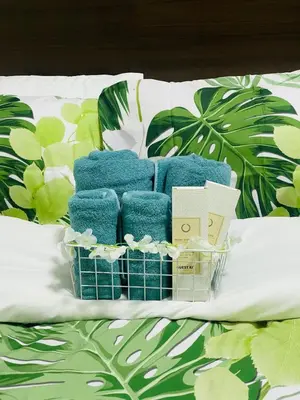a pile of blue towels on a bed with leaves at Tropical Chic Escape With City lights View- Modern Scandi in Manila
