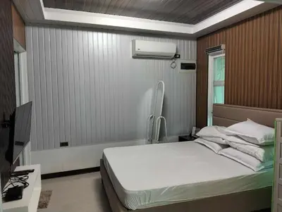a bedroom with a white bed and a window at Delia Secret Garden in Silang