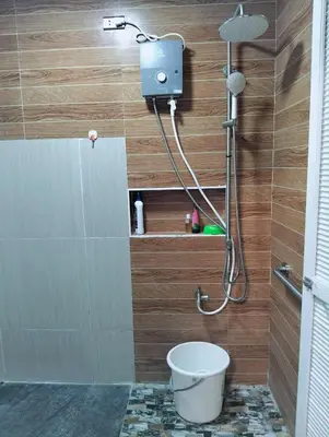 a bathroom with a shower with a toilet in it at Delia Secret Garden in Silang