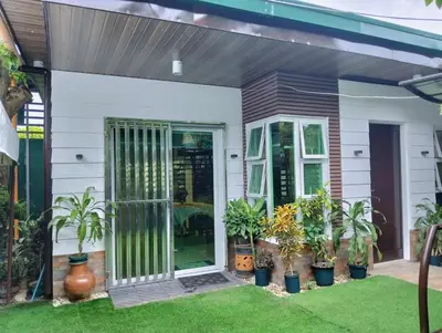 a front door of a house with potted plants at Delia Secret Garden in Silang