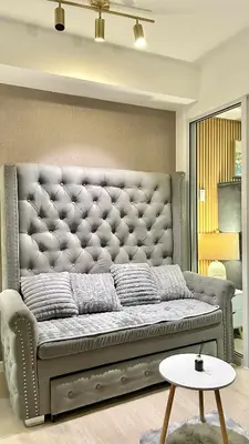 a large couch in a living room with a table at Azure Skyline Pad in Manila