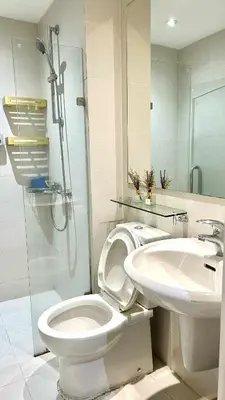 a bathroom with a toilet and a sink and a shower at Azure Skyline Pad in Manila