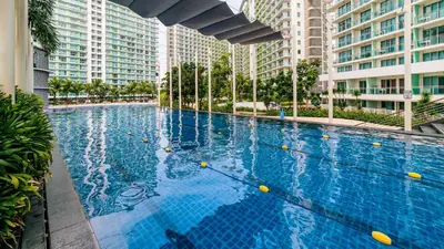 a large swimming pool in a building with tall buildings at Azure Skyline Pad in Manila