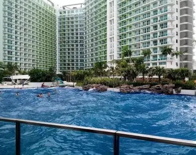 a large swimming pool in front of tall buildings at Azure Skyline Pad in Manila