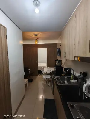 a kitchen with a sink and a room with a bed at Shore Residences MOA in Manila