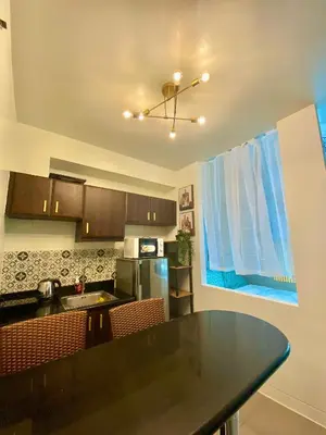 a kitchen with a black counter top in a room at Cozy Cabin by JLS Near Venice Grand Canal Mall in Manila