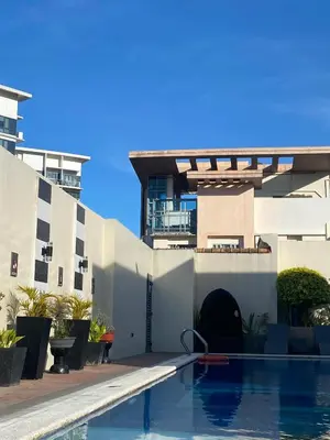 a swimming pool in front of a building at Cozy Cabin by JLS Near Venice Grand Canal Mall in Manila