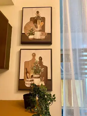 three framed pictures on a wall with a plant at Cozy Cabin by JLS Near Venice Grand Canal Mall in Manila