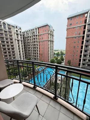 a balcony with tables and chairs and buildings at Monarch Parksuites 1BR with balcony in Manila