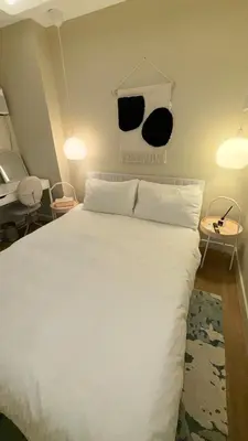 a bedroom with a large white bed and two tables at Best Value-Beautiful 1BR in the Heart of Makati w WiFi, washer-dryer, pool & gym in Manila