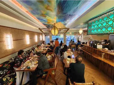 a group of people sitting at tables in a restaurant at Best Value-Beautiful 1BR in the Heart of Makati w WiFi, washer-dryer, pool & gym in Manila