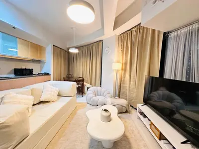 a living room with a couch and a flat screen tv at The Dreamy Cloud by Kozy Mood in Manila